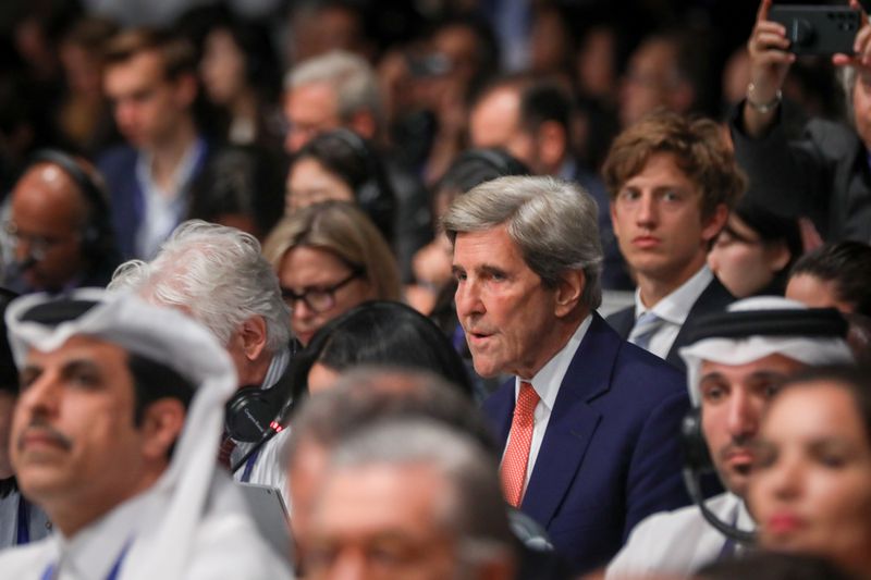Kerry is pictured in a crowd of people at COP28.
