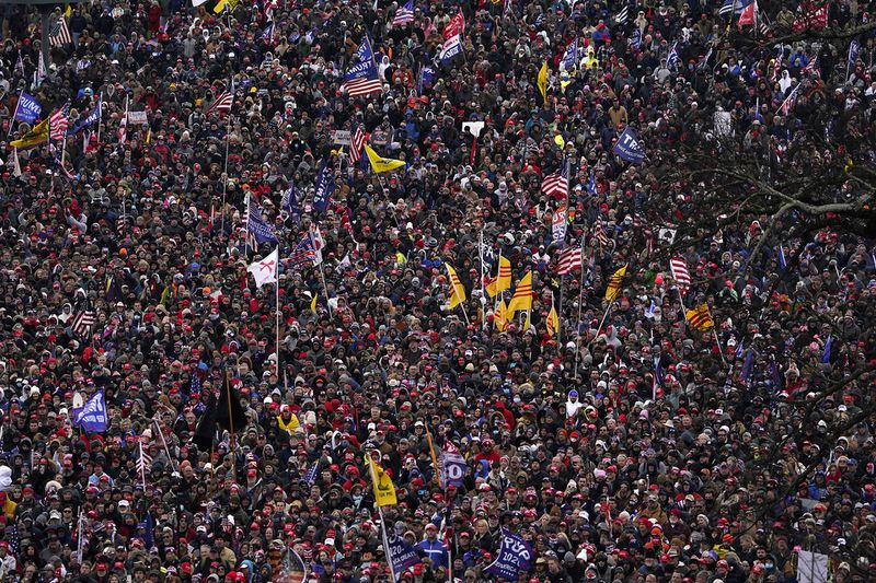 An overhead shot of a crowd of people, many holding flags. 