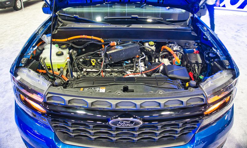 The engine bay of a blue Ford Maverick hybrid truck.